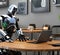 A metal robot sits in a cafe with a laptop. AI generated