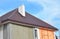 Metal roof construction with chimney installation, stucco, plastering and painting house wall. Metal Roofing Construction
