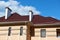 Metal roof and walls of new private house, with chimneys and ventilation on the background of sky, construction concept, family re