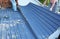 Metal roofing construction. Two building contractors are laying down and installing large metal roofing sheets onto the roof