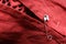 Metal safety pin on red fabric, closeup