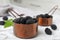 Metal saucepans with ripe blackberries on marble