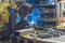 Metal shop welding in progress sparks fly while young man`s work
