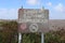 Metal sign at Bossington beach in Somerset warning that Bathing in the sea is dangerous. The sign is dented an looks as if it has