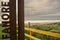 Metal sign Fanore , county Clare, Ireland. Sandy beach and ocean out of focus in the background. Popular travel destination on