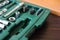 Metal socket wrench kit in a green plastic container
