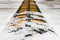 Metal speed bump painted in yellow color for security reasons covered by first snow, cold winter season concept, snowfall is a