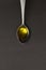 Metal spoon with extra virgin olive oil. on a dark background. Spanish olive oil, healing power of oil