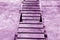 Metal stairway on cement wall in purple tone.
