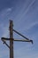 Metal stanchion with heavy rusted patina against a blue sky with light clouds