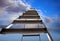 Metal stepladder against sky with clouds, low angle view