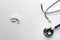 Metal stethoscope for medical doctor health diagnosis with white drug pill on table background