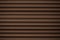 Metal striped pattern. Dark brown ribbed siding texture. Lines of fence, abstract grooved background