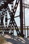 The metal structure of the old bridge across the strait . Old railway, road and pedestrian bridge