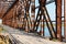 The metal structure of the old bridge across the strait . Old railway, road and pedestrian bridge