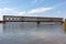 The metal structure of the old bridge across the strait . Old railway, road and pedestrian bridge