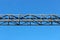 Metal structure on the railway against the blue sky.