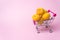 A metal supermarket trolley in miniature with apricots. Shopping, purchases, supermarket, sale, mall concept. Grocery supermarket