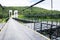 Metal suspension bridge at Mae kuang Udom Thara dam background in Chiang mai, Thailand