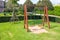 Metal swings hanging on chain place on green grass meadow field.