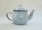 Metal teapot with batik motif on white background