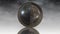 Metal terrestrial globe rotating between two hemispheres on cloud background