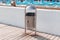 Metal trash bin with an office bag on the waterfront near the hotel. Global pollution concept. Clean city street with a