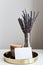 Metal tray with aroma candle, dried lavender flowers in a vase and blank paper card