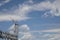 Metal truss structure of an electrical power substation against a dramatic blue sky with white clouds, creative copy space