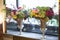 Metal vases in the form of a goblet with bouquets of flowers are on the windowsill