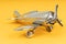 Metal vintage aircraft toy, with front propeller. Retro toy on yellow background