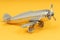 Metal vintage aircraft toy, with front propeller. Retro toy on yellow background