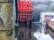 Metal wall fence by the river and a piece of building in Heywood