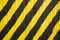 Metal wall with yellow and black wide diagonal lines. rough surface texture