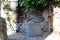 Metal watering can on gravel in front of the wall