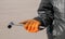Metal wheel wrench in the hands of a man wearing orange gloves and a black twist