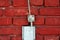 Metal wires used as lightning conductor protection system mounted on red brick wall