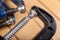 Metal wood clamp on a workshop table. Carpentry accessories in a wood workshop