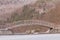 Metal and wood foot bridge over a frozen pond