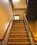 Metal and wooden Stair with beige wall and shadows. Stairway, staircase, stairwell