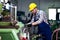 Metal worker turner operating lathe machine at industrial manufacturing factory.