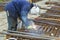 Metal worker welds a metal construction for cables