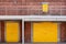 Metal yellow factory door on brick wall