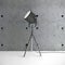 Metalic tripod lamp and concrete wall in empty room