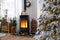 Metall black stove, burning hearth fireplace in white Festive interior of house is decorated for Christmas and New Year, Christmas
