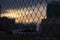 Metall wire fence with unfocused city and sunset backgorund