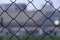 Metall wire fence with unfocused city and sunset backgorund