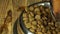 Metallic bowl with dry food for pets in macro view and a black dog`s nose eating it in slow motion