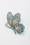 Metallic brooch in shape of butterfly with gemstones imitation, pin on white background, bijouterie, jewelry close up