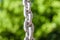 Metallic chain in clear silver color and blurred background of trees